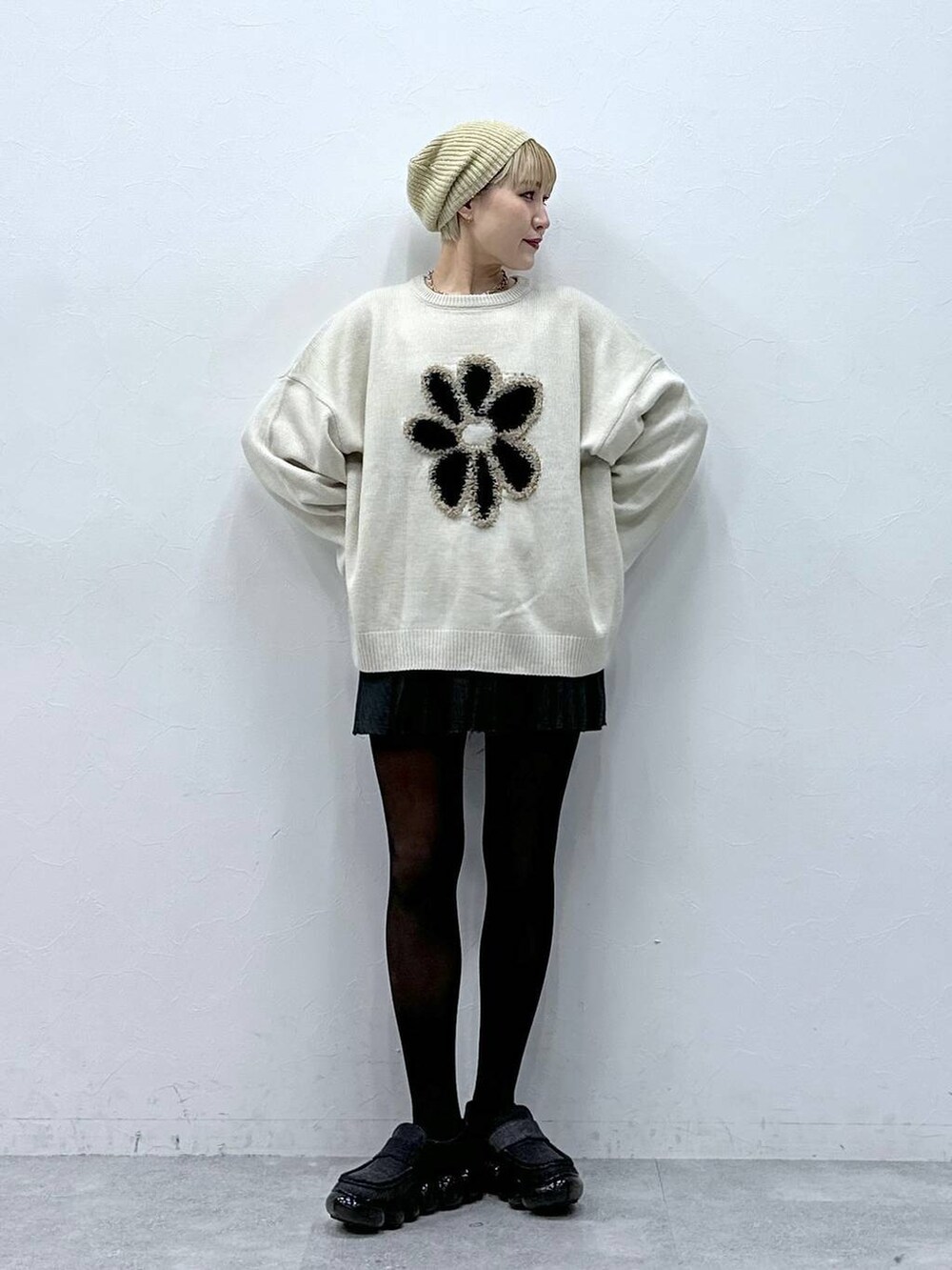 グレー系のスカート、ホワイト系のニット/セーター、ベージュ系のハンチング/ベレー帽を着用したレディースの冬コーディネートの3枚目の写真