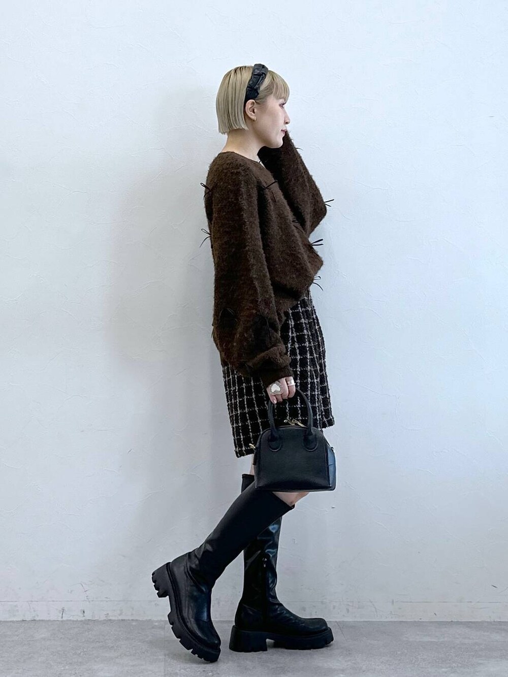 ブラック系のブーツ、ブラウン系のその他パンツ、ブラウン系のニット/セーターを着用したレディースの冬コーディネートの4枚目の写真