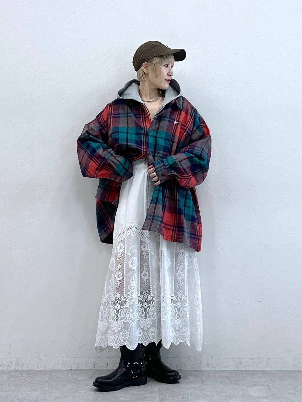 レッド系のシャツ/ブラウス、ブラック系のブーツ、ホワイト系のスカートを着用したレディースの秋コーディネートの3枚目の写真