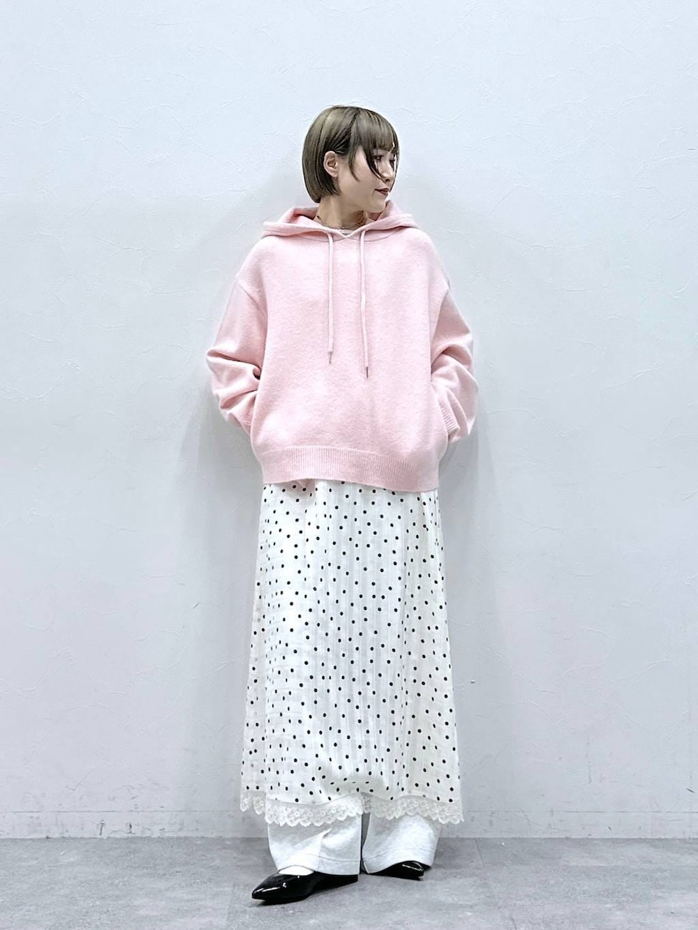 ホワイト系のTシャツ/カットソー、ブラック系のパンプス、ピンク系のニット/セーターを着用したレディースの冬コーディネートの3枚目の写真