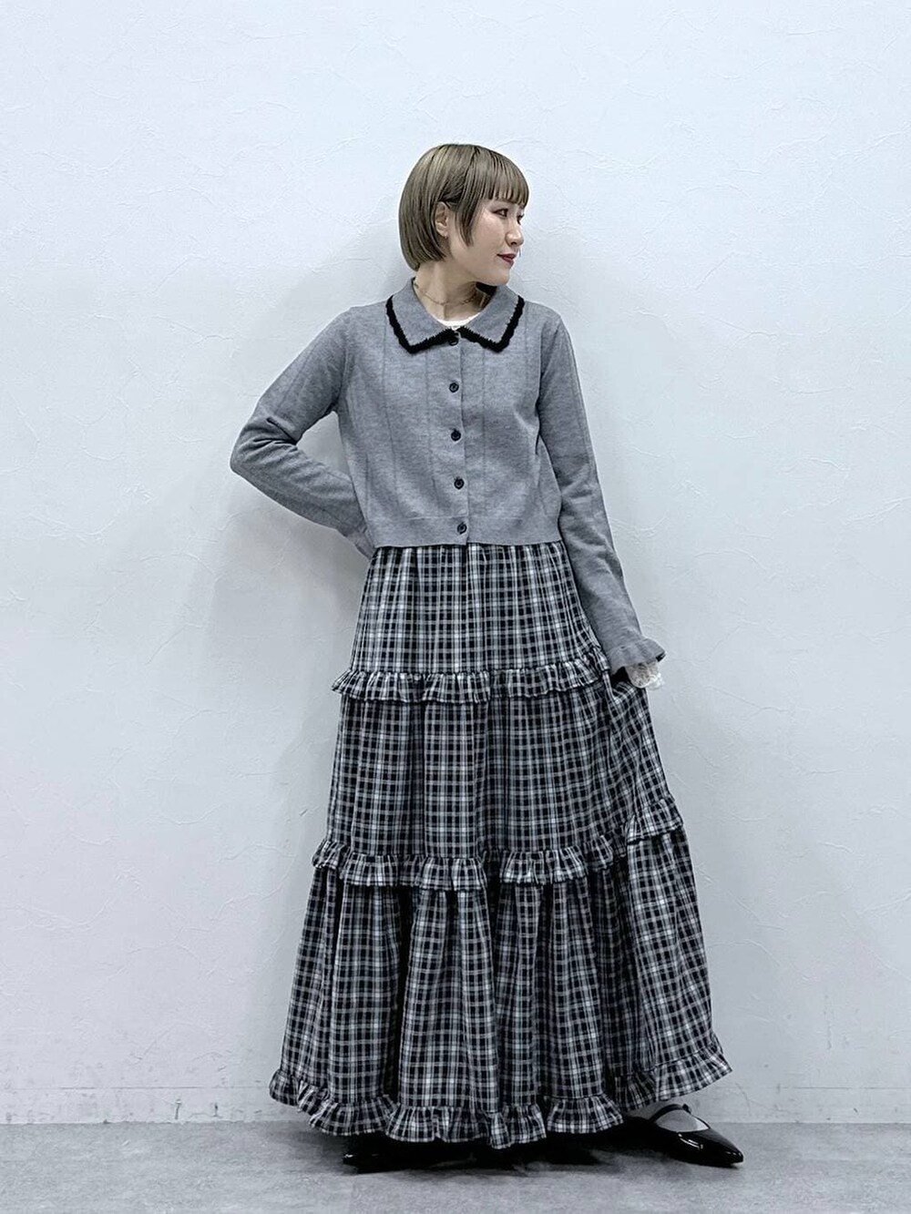 ホワイト系のTシャツ/カットソー、ブラック系のパンプス、グレー系のカーディガン/ボレロを着用したレディースの冬コーディネートの2枚目の写真
