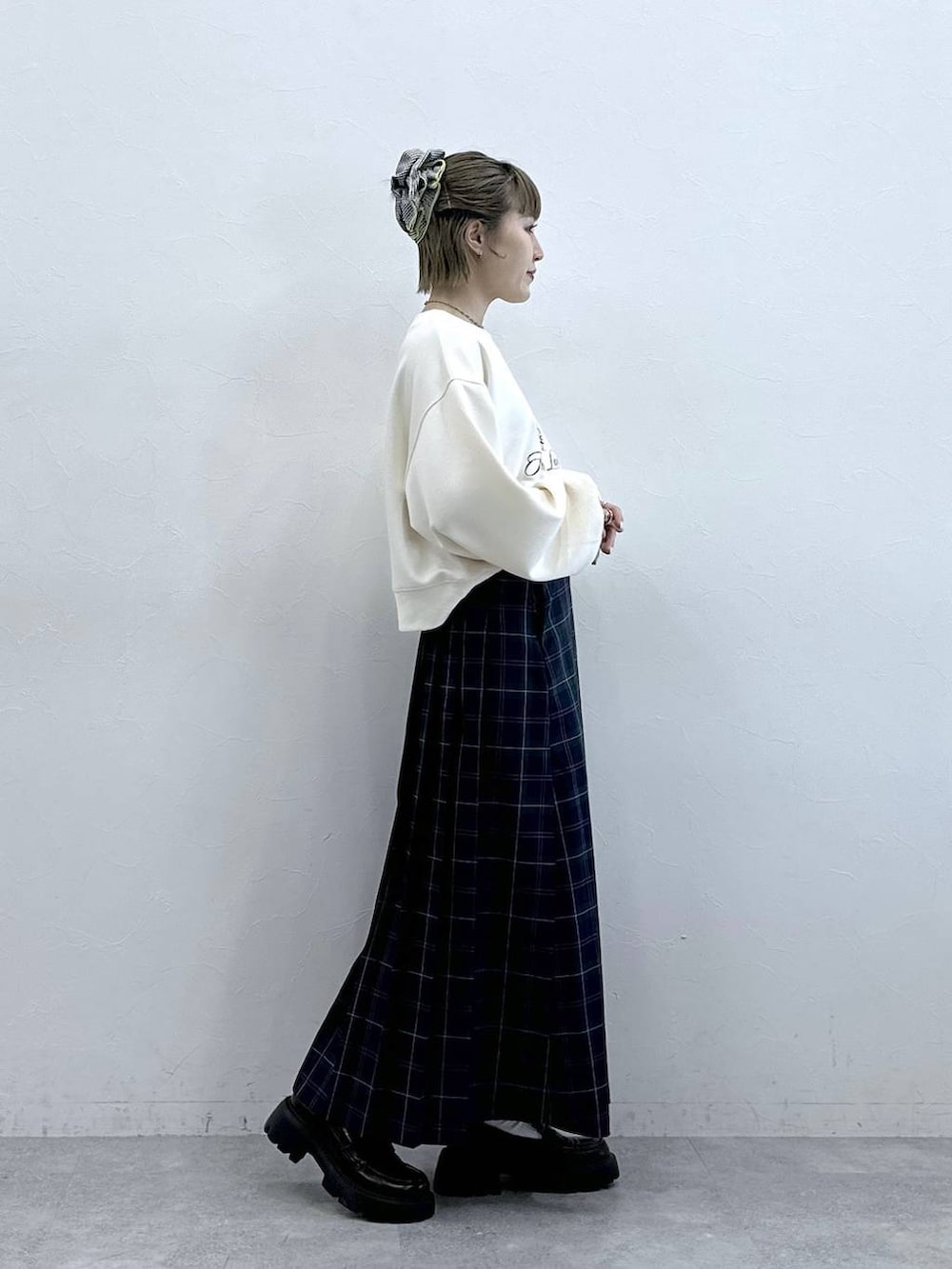 ブラウン系のローファー、グリーン系のスカート、ホワイト系のスウェットを着用したレディースの冬コーディネートの4枚目の写真