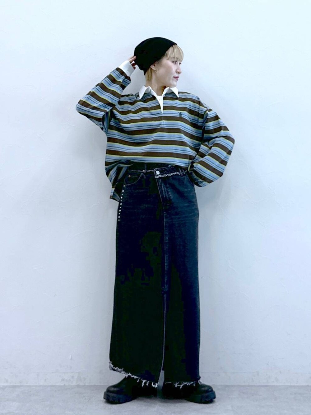 ブラック系のブーツ、ブラック系のデニムスカート、ブラウン系のポロシャツを着用したレディースの冬コーディネートの3枚目の写真