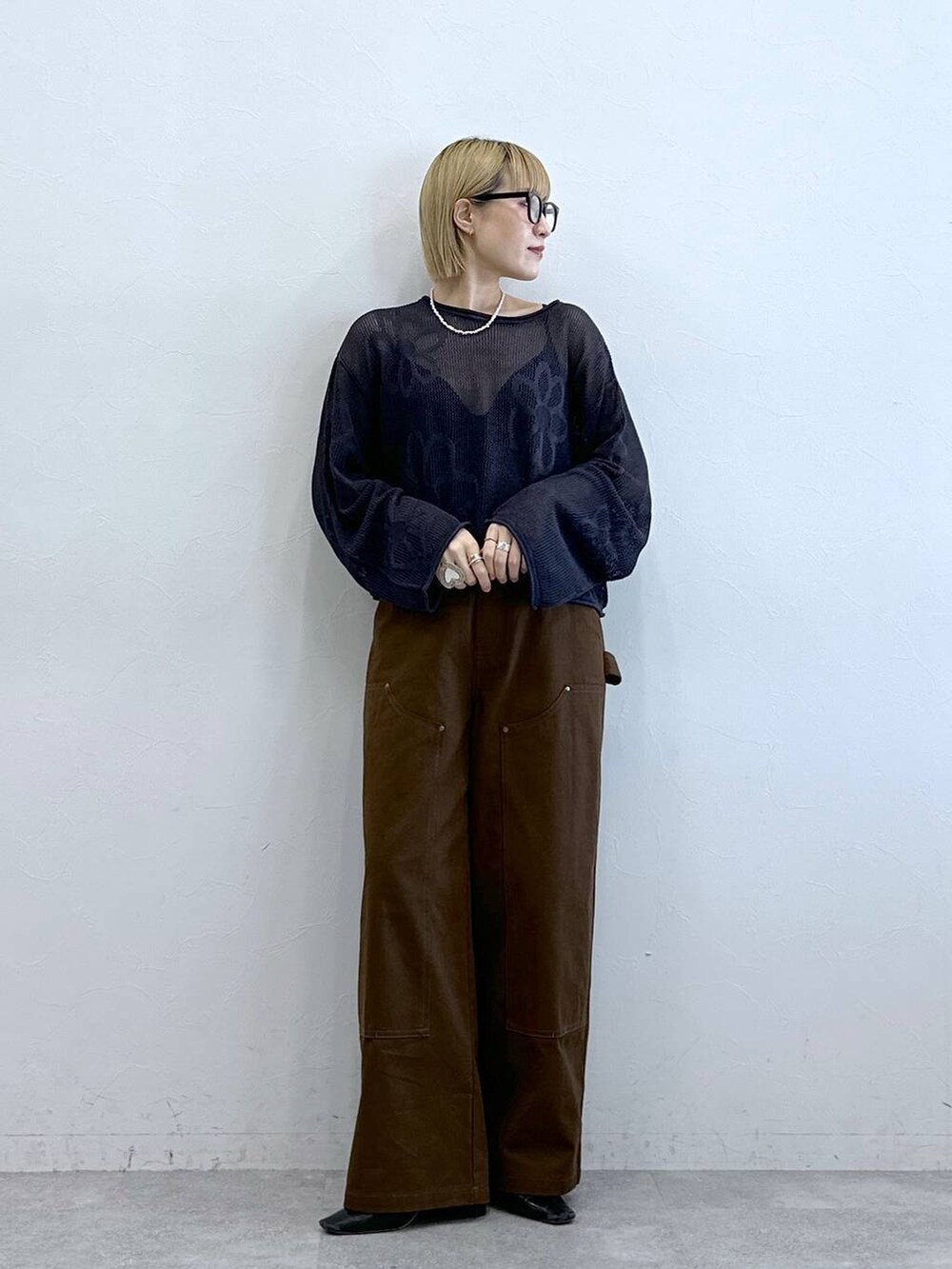 グレー系のニット/セーター、ブラウン系のチノパンツ、グレー系のメガネを着用したレディースの夏コーディネートの4枚目の写真