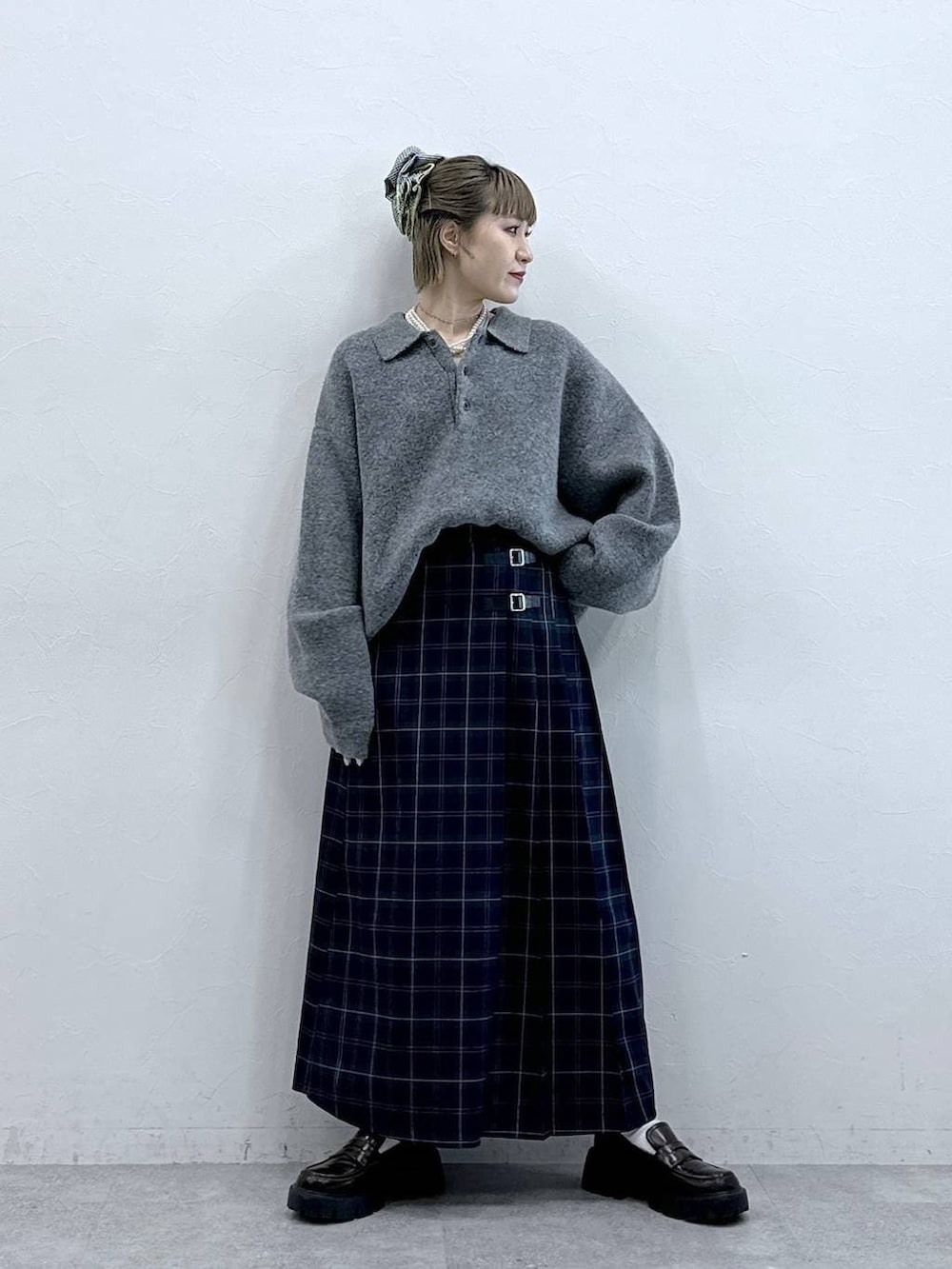 ブラック系のローファー、グリーン系のスカート、グレー系のポロシャツを着用したレディースの冬コーディネートの3枚目の写真