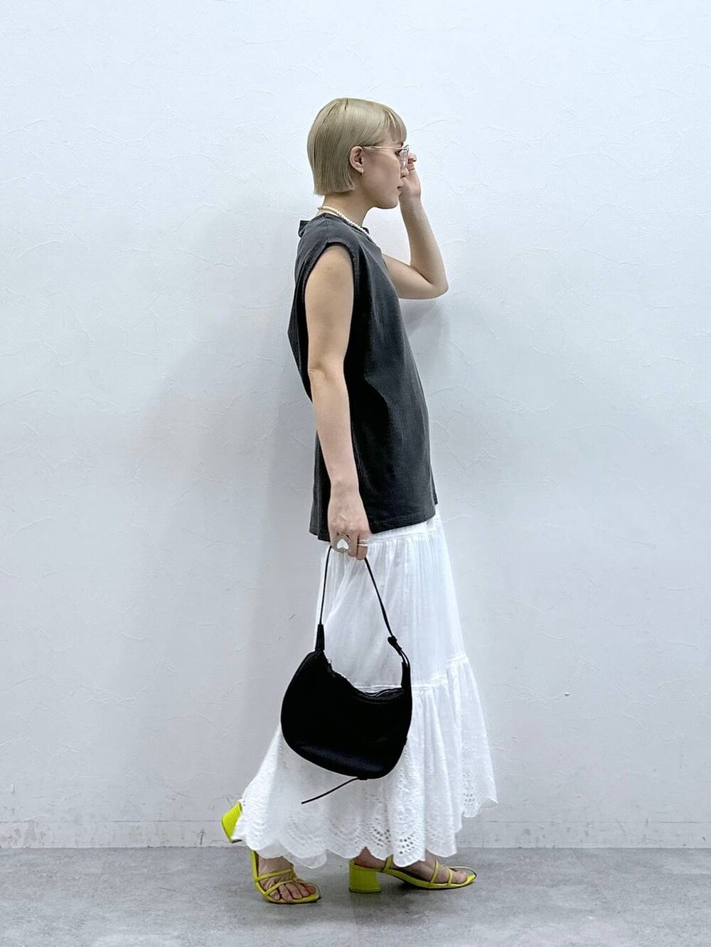 ブラック系のTシャツ/カットソー、ホワイト系のスカート、ブラック系のメガネを着用したレディースの夏コーディネートの4枚目の写真