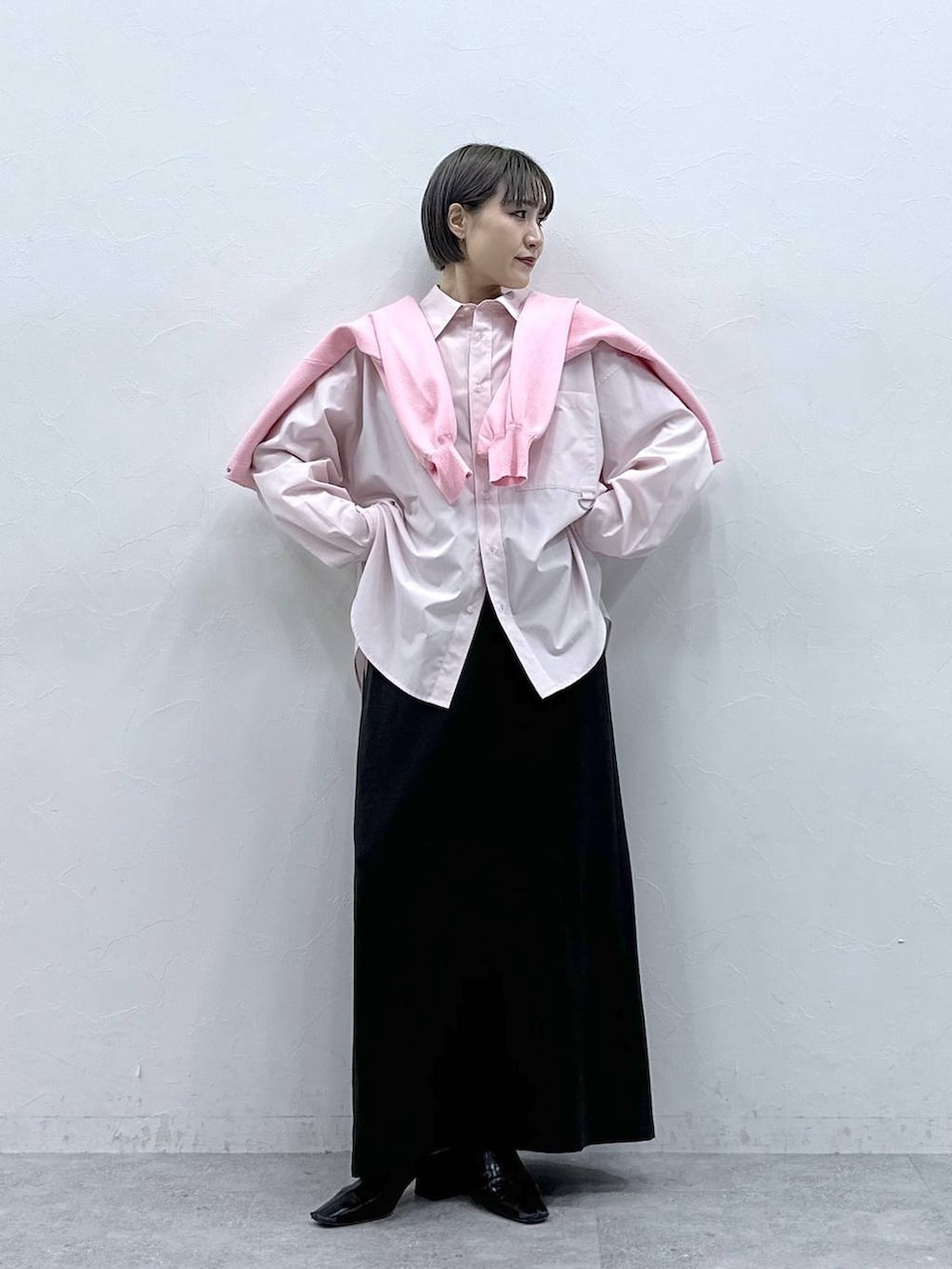 ピンク系のカーディガン/ボレロ、ブラック系のスカート、ピンク系のシャツ/ブラウスを着用したレディースの春コーディネートの5枚目の写真
