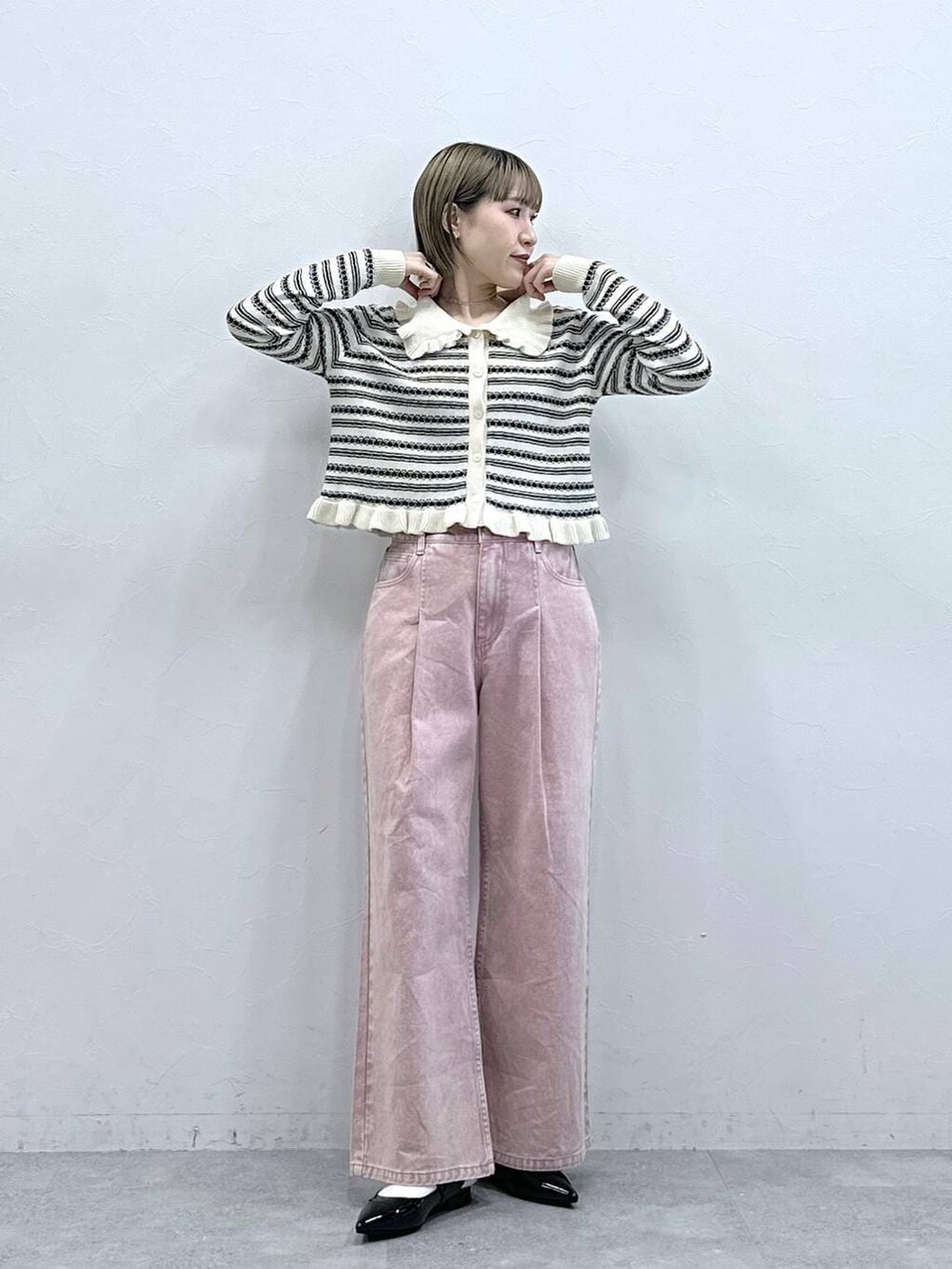 ブラック系のパンプス、ピンク系のデニムパンツ、ホワイト系のカーディガン/ボレロを着用したレディースの冬コーディネートの4枚目の写真