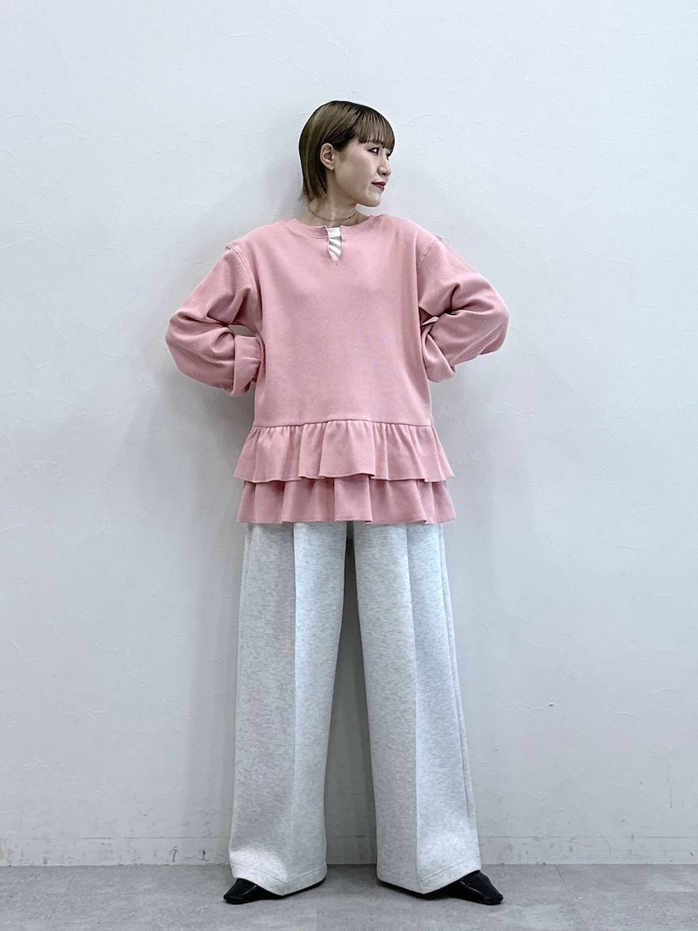 ホワイト系のスウェットパンツ、ピンク系のスウェット、ホワイト系のTシャツ/カットソーを着用したレディースの冬コーディネートの3枚目の写真