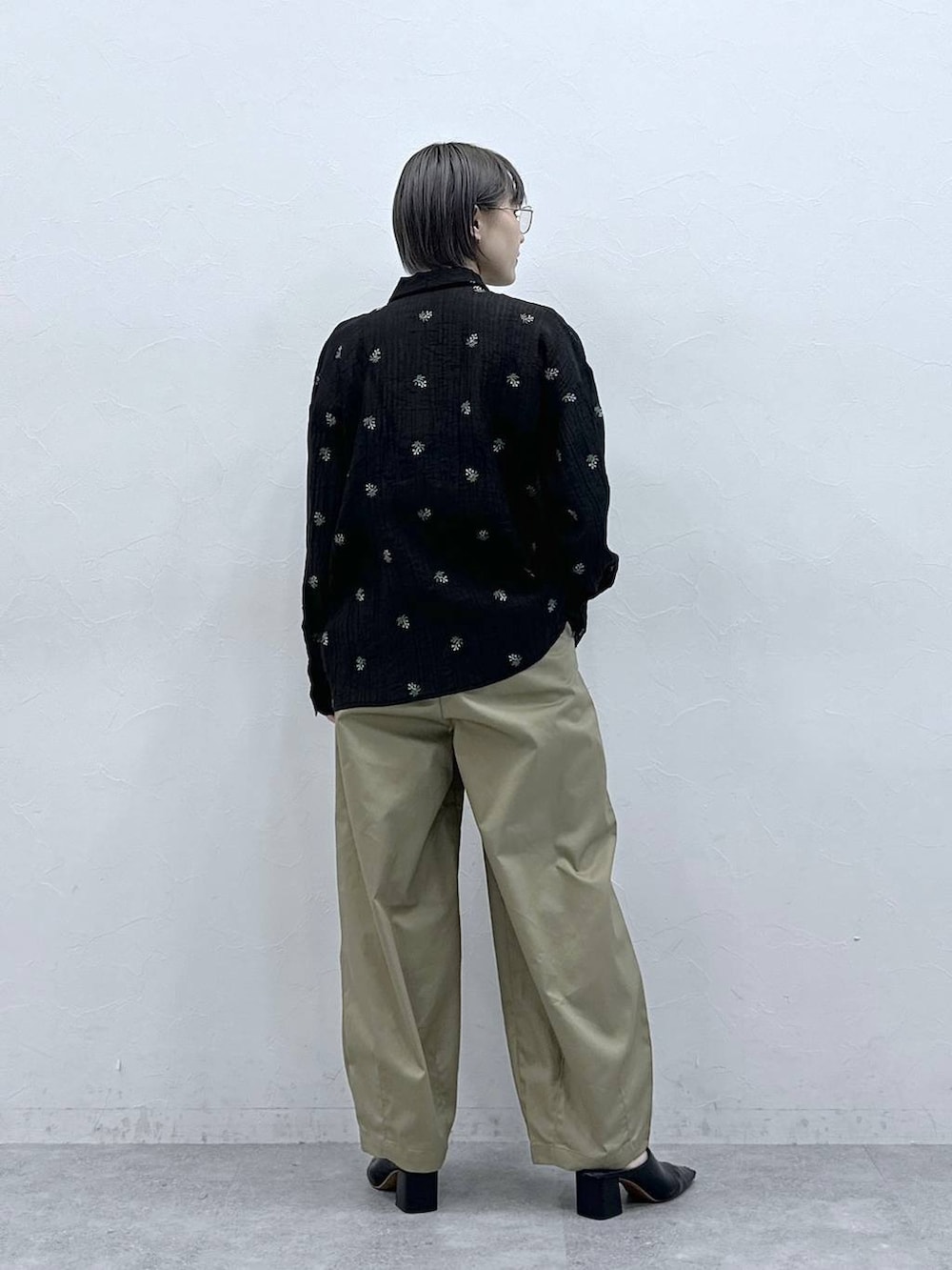 ベージュ系のチノパンツ、ブラック系のシャツ/ブラウスを着用したレディースの春コーディネートの5枚目の写真