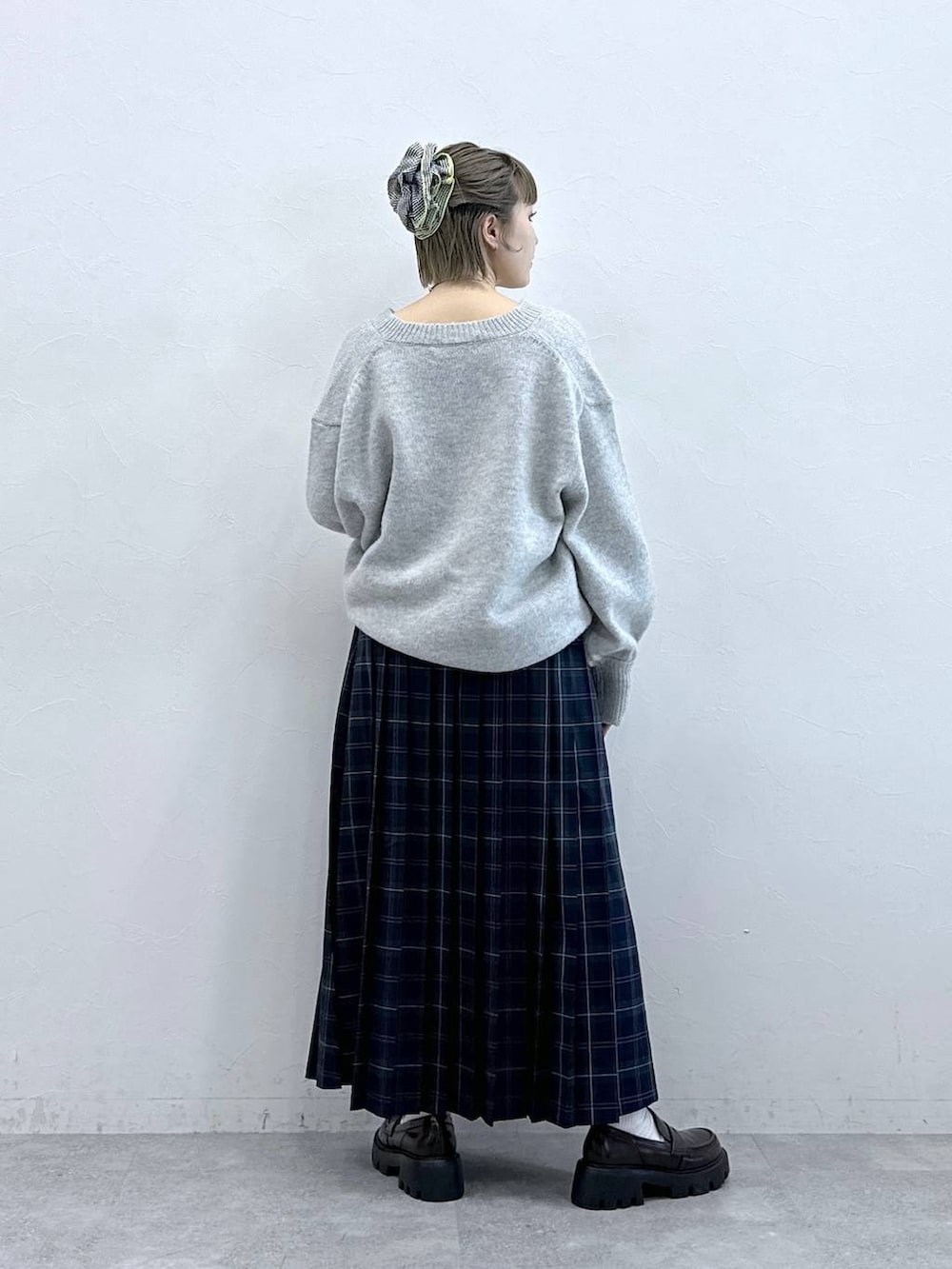 ブラック系のローファー、グリーン系のスカート、グレー系のニット/セーターを着用したレディースの冬コーディネートの5枚目の写真