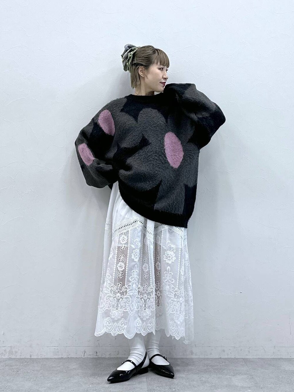 ブラック系のニット/セーター、ホワイト系のスカート、ブラック系のパンプスを着用したレディースの冬コーディネートの3枚目の写真