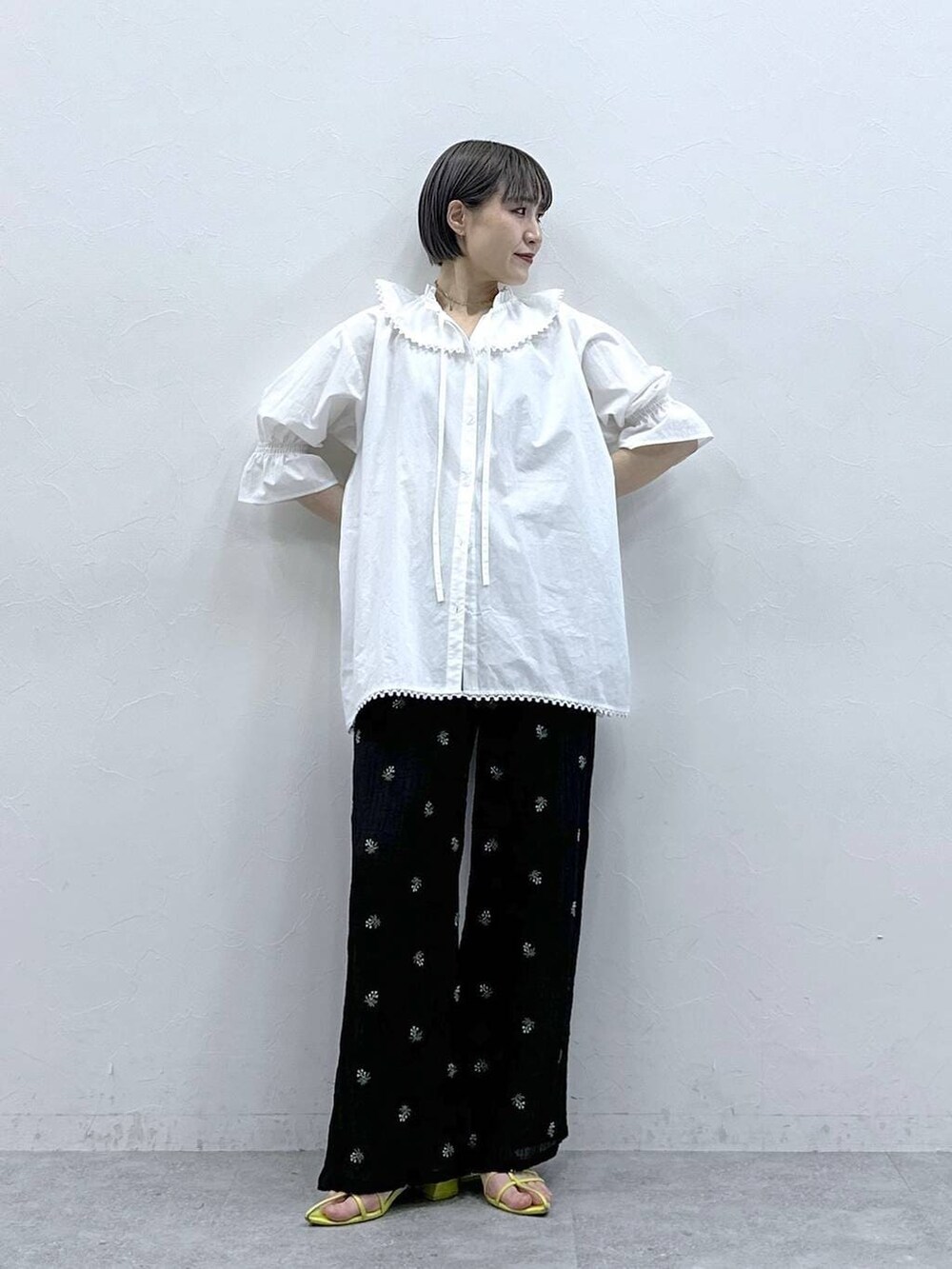 ブラック系のスラックス、ホワイト系のシャツ/ブラウスを着用したレディースの春コーディネートの2枚目の写真