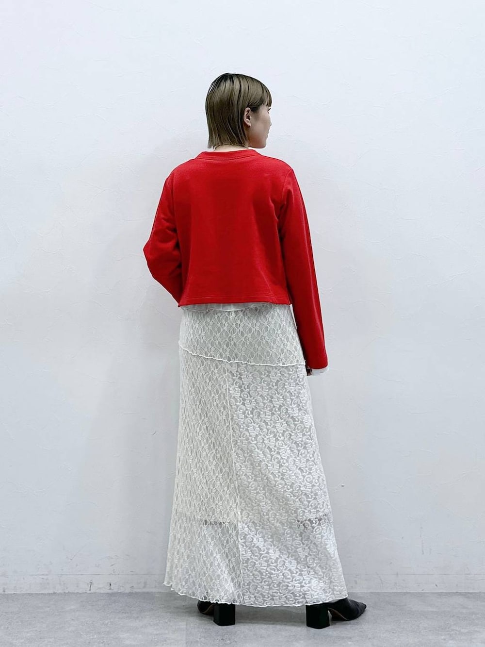 レッド系のカーディガン/ボレロ、ホワイト系のTシャツ/カットソー、ホワイト系のスカートを着用したレディースの冬コーディネートの5枚目の写真