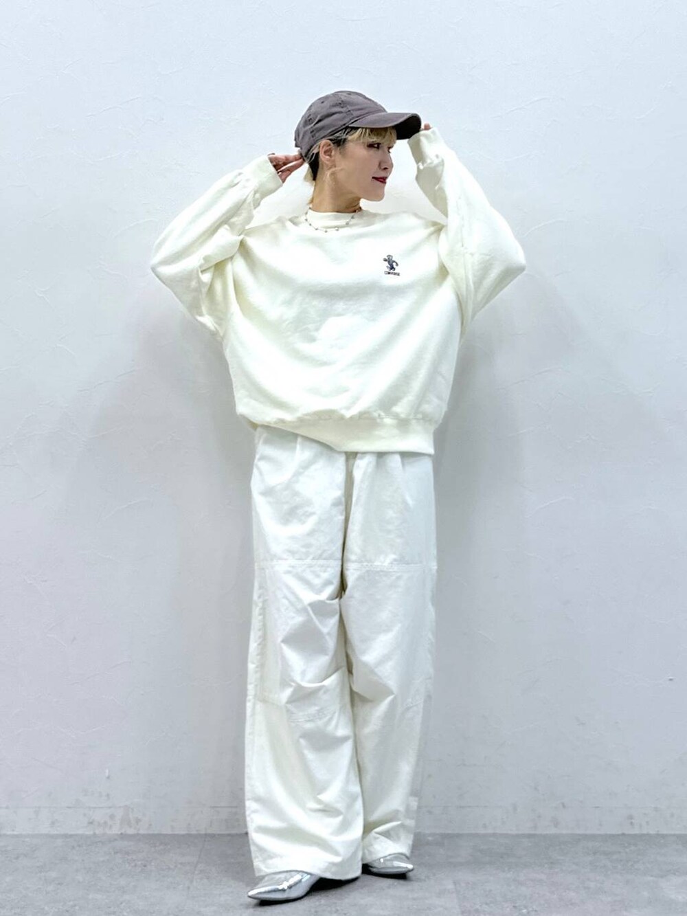 シルバー系のパンプス、ホワイト系のカーゴパンツ、ホワイト系のスウェットを着用したレディースの秋コーディネートの3枚目の写真