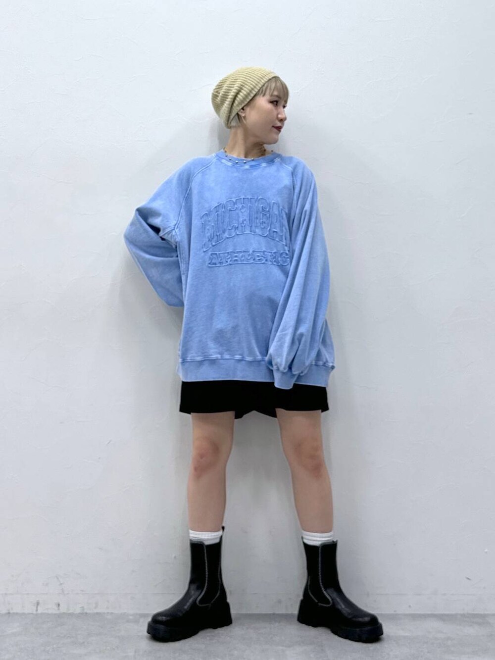 ブラック系のチノパンツ、ブラック系のブーツ、ブルー系のスウェットを着用したレディースの秋コーディネートの2枚目の写真