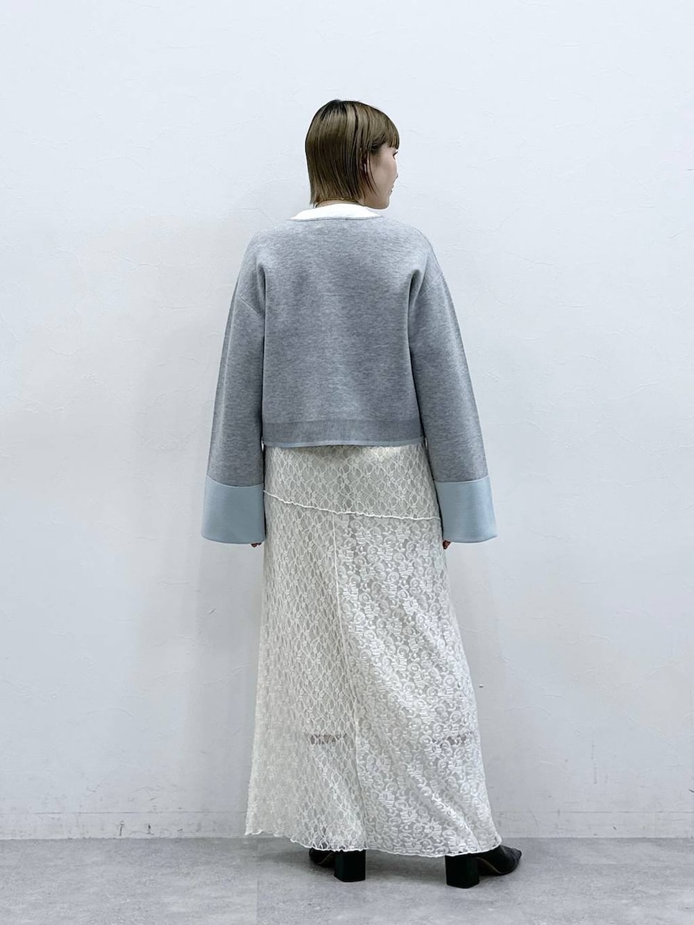 グレー系のカーディガン/ボレロ、ホワイト系のスカートを着用したレディースの冬コーディネートの5枚目の写真