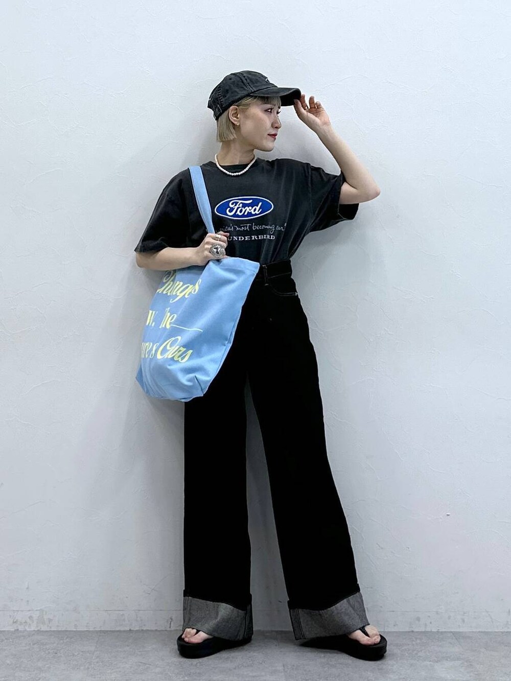 ブラック系のTシャツ/カットソー、ブラック系のデニムパンツ、ピンク系のトートバッグを着用したレディースの夏コーディネートの3枚目の写真