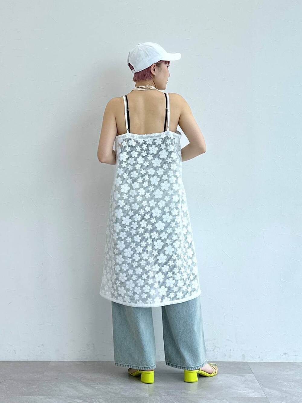 ブルー系のデニムパンツ、ホワイト系のワンピースを着用したレディースの春コーディネートの5枚目の写真