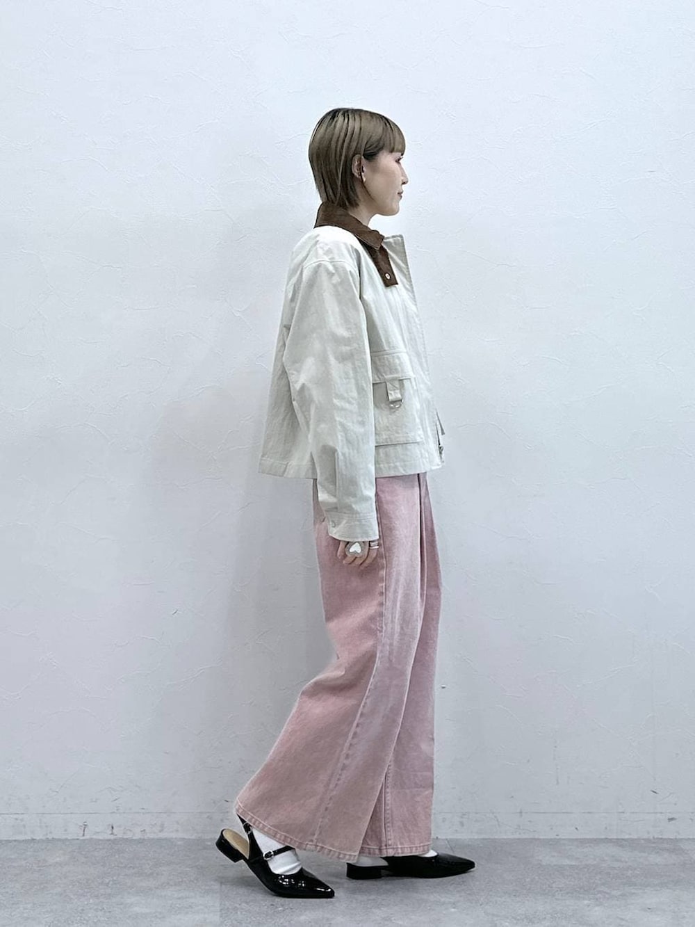 ブラック系のパンプス、ピンク系のデニムパンツ、ホワイト系のブルゾンを着用したレディースの冬コーディネートの4枚目の写真