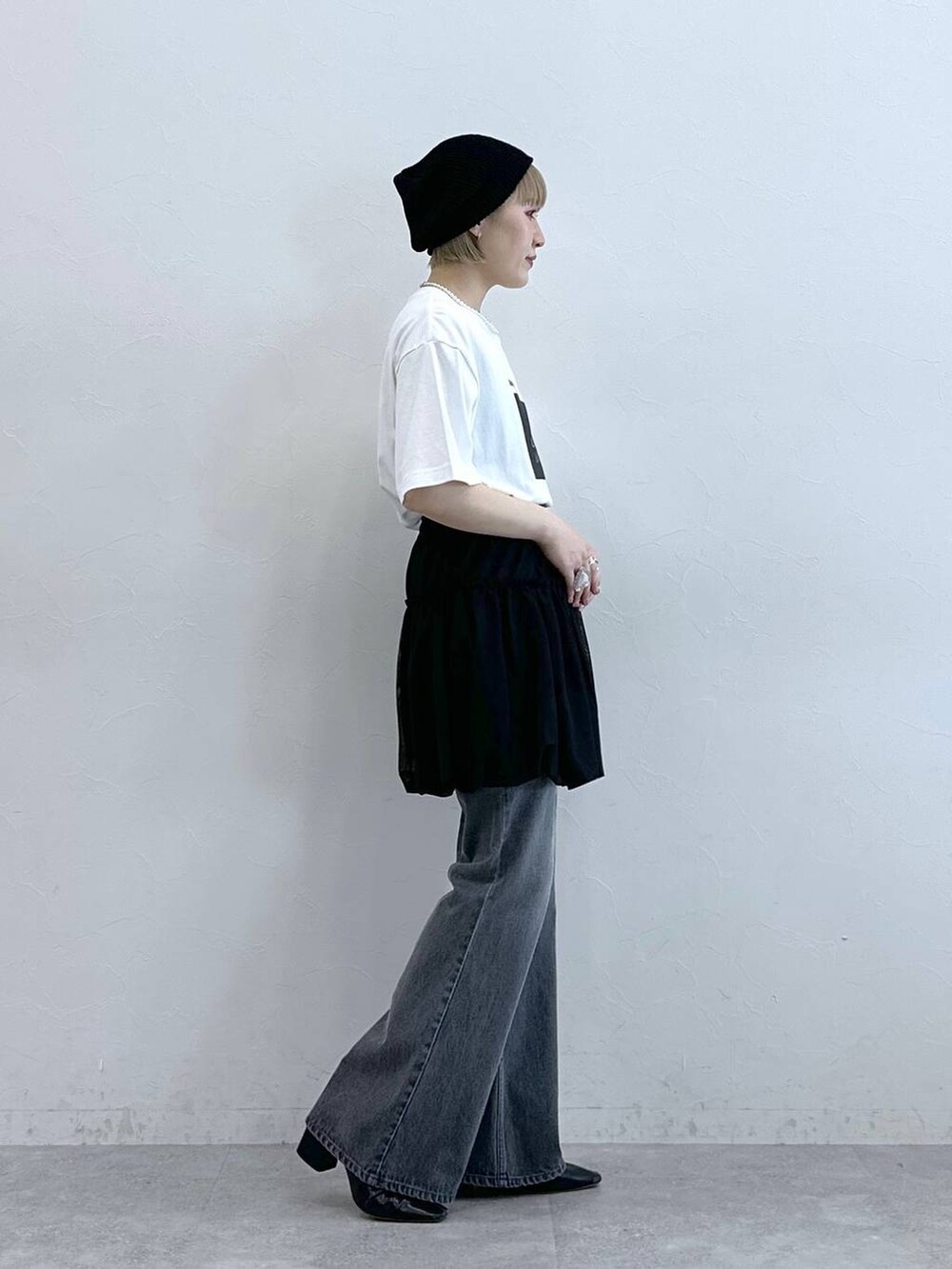 グレー系のデニムパンツ、ブラック系のスカート、ブラック系のニットキャップ/ビーニーを着用したレディースの夏コーディネートの5枚目の写真