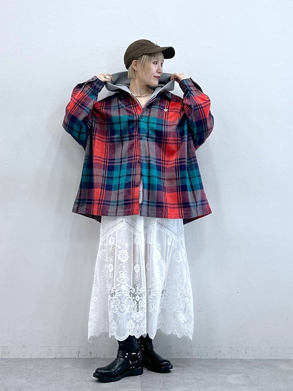 レッド系のシャツ/ブラウス、ブラック系のブーツ、ホワイト系のスカートを着用したレディースの秋コーディネートの4枚目の写真