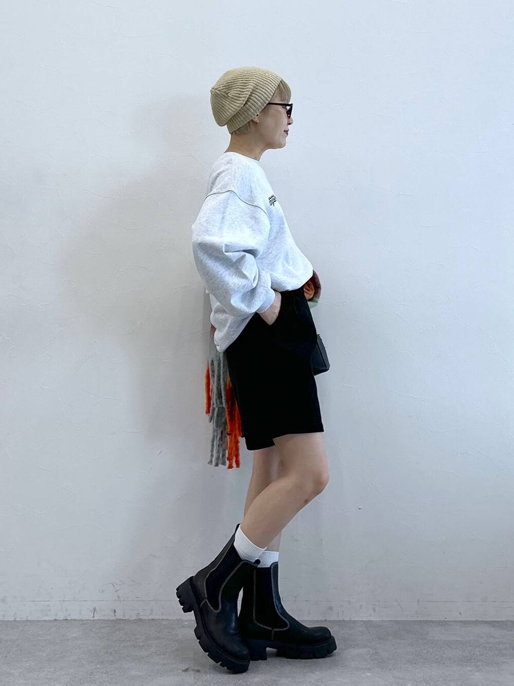 ブラック系のチノパンツ、ブラック系のブーツ、グレー系のスウェットを着用したレディースの冬コーディネートの3枚目の写真