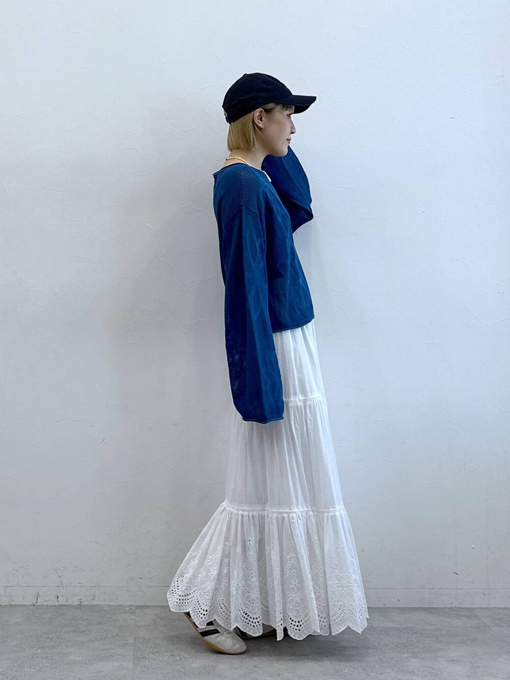 ホワイト系のスニーカー、ホワイト系のスカート、ブルー系のニット/セーターを着用したレディースの夏コーディネートの5枚目の写真