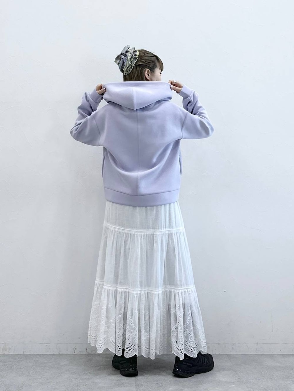 パープル系のパーカー、ホワイト系のスカートを着用したレディースの冬コーディネートの6枚目の写真