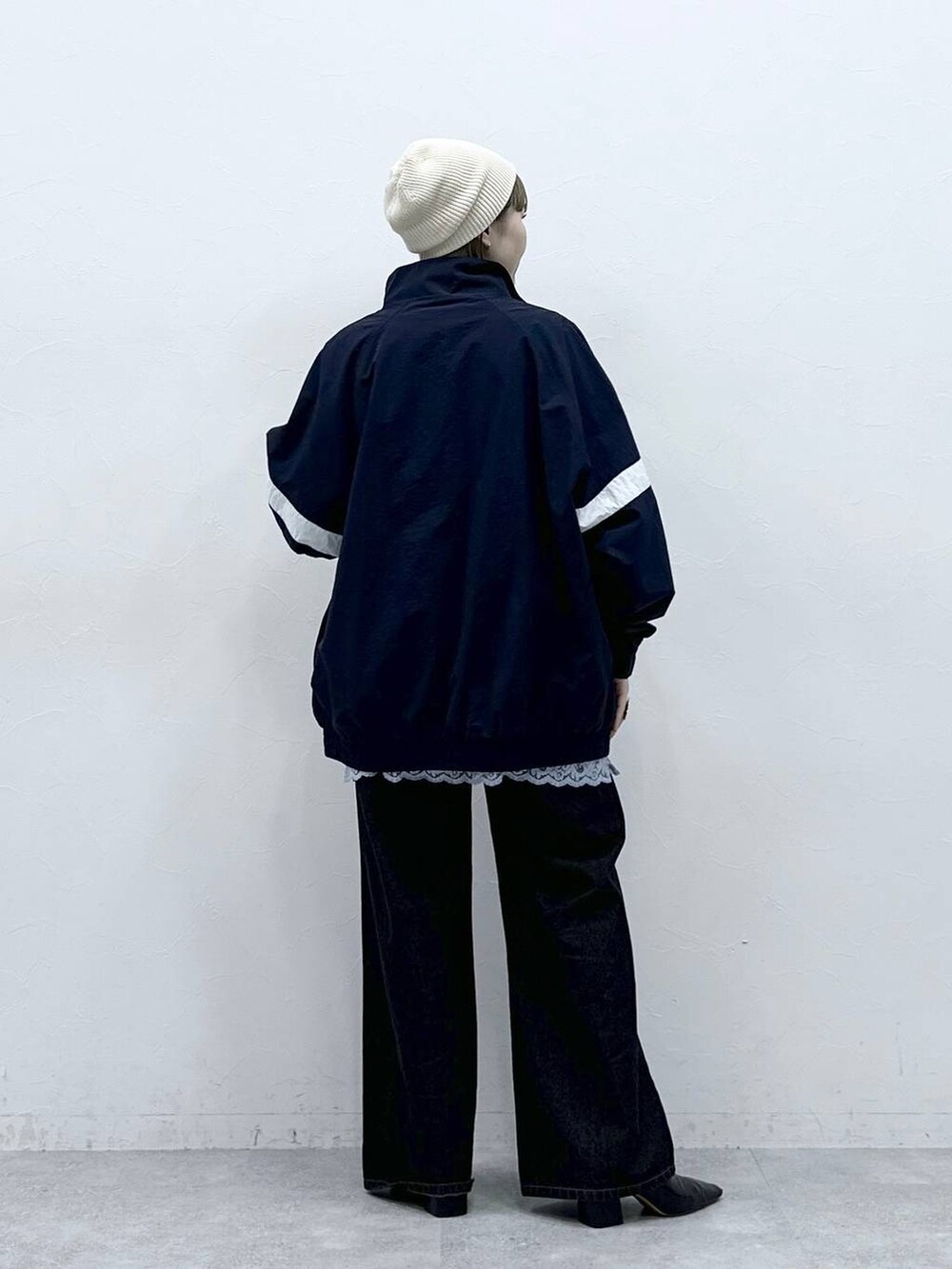 ブルー系のブルゾン、ブラック系のデニムパンツ、ブルー系のキャミソールを着用したレディースの冬コーディネートの5枚目の写真