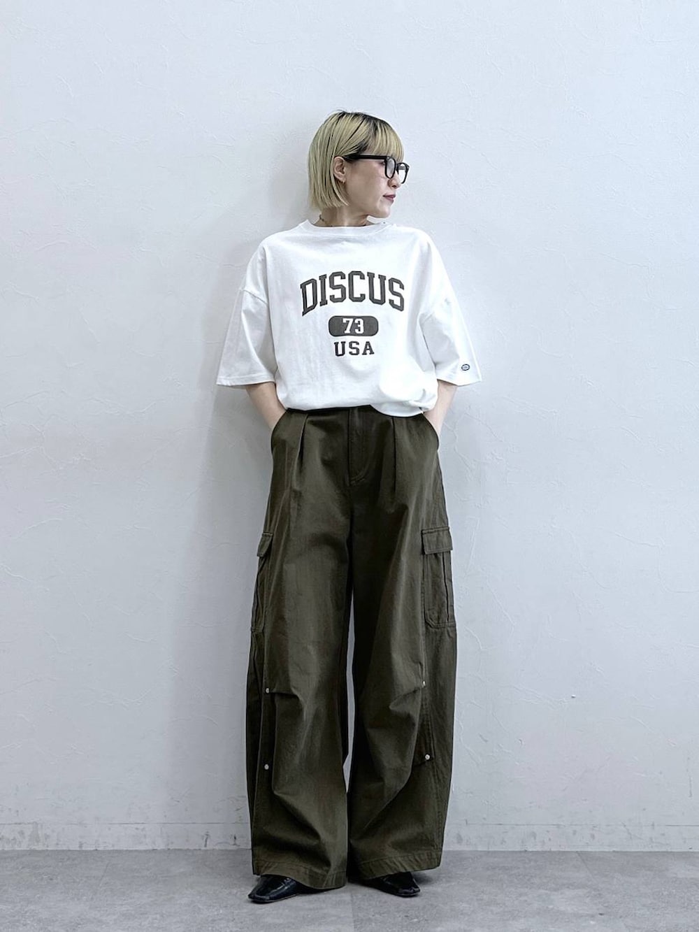 グリーン系のカーゴパンツ、ホワイト系のTシャツ/カットソーを着用したレディースの夏コーディネートの3枚目の写真