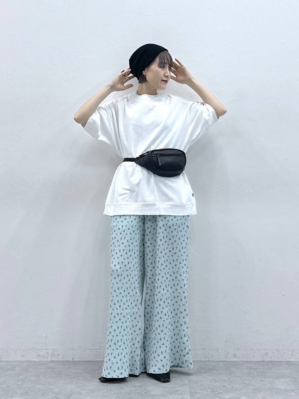 ホワイト系のTシャツ/カットソー、ブラック系のボディバッグ/ウエストポーチ、ブルー系のスラックスを着用したレディースの春コーディネートの2枚目の写真