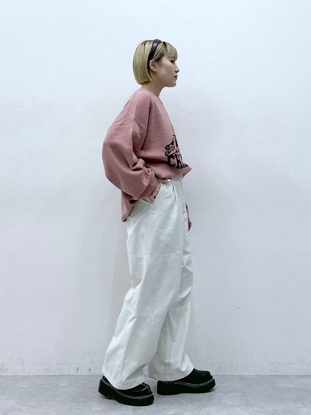 ブラック系のローファー、ホワイト系のカーゴパンツ、ピンク系のニット/セーターを着用したレディースの冬コーディネートの4枚目の写真