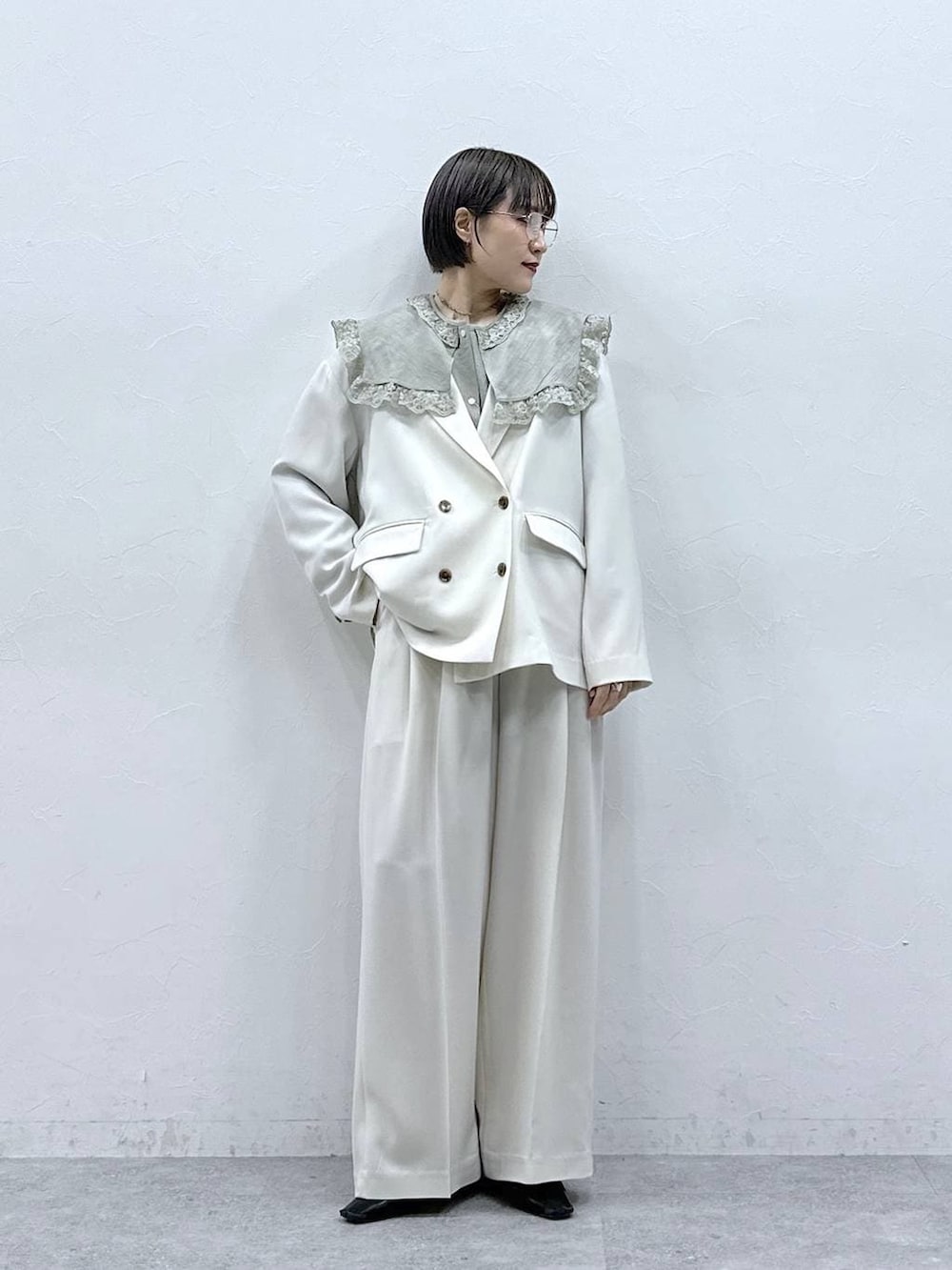 グリーン系のシャツ/ブラウス、ホワイト系のテーラードジャケット、ホワイト系のスラックスを着用したレディースの春コーディネートの3枚目の写真