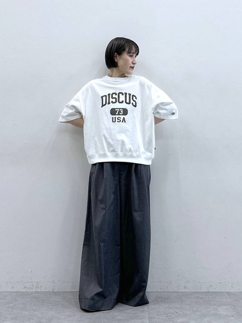 ホワイト系のTシャツ/カットソー、グレー系のスラックスを着用したレディースの春コーディネートの6枚目の写真