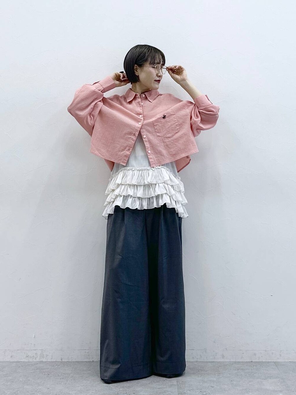 ホワイト系のキャミソール、ピンク系のシャツ/ブラウス、グレー系のスラックスを着用したレディースの春コーディネートの4枚目の写真