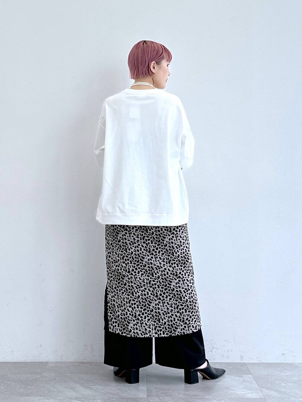 ホワイト系のTシャツ/カットソー、ブラック系のスラックス、ベージュ系のスカートを着用したレディースの春コーディネートの5枚目の写真