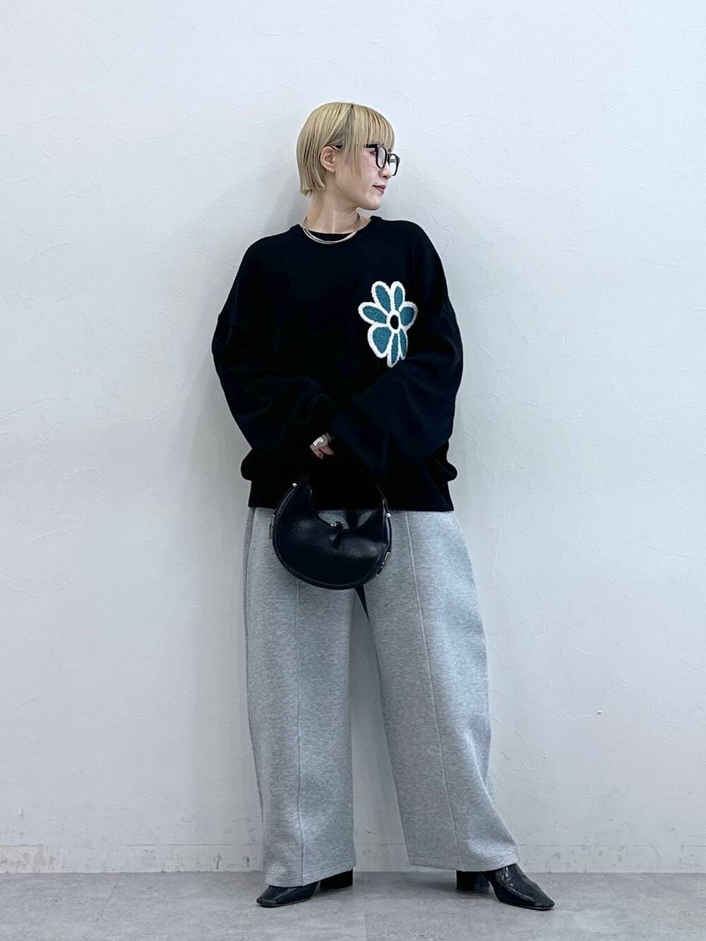 ブラック系のニット/セーター、グレー系のスウェットパンツ、グレー系のメガネを着用したレディースの秋コーディネートの3枚目の写真