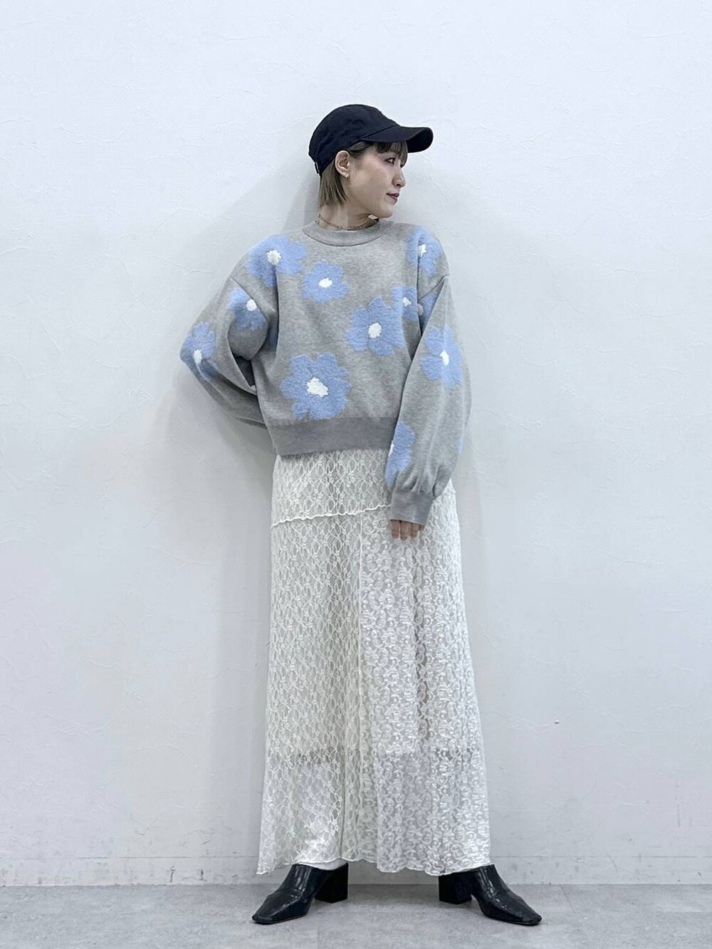 グレー系のニット/セーター、ホワイト系のスカートを着用したレディースの冬コーディネートの5枚目の写真