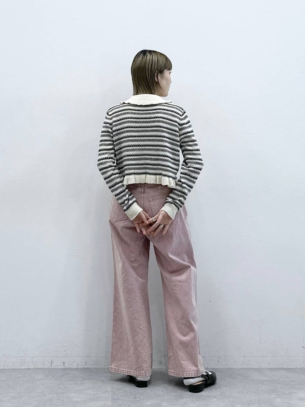 ブラック系のパンプス、ピンク系のデニムパンツ、ホワイト系のカーディガン/ボレロを着用したレディースの冬コーディネートの7枚目の写真