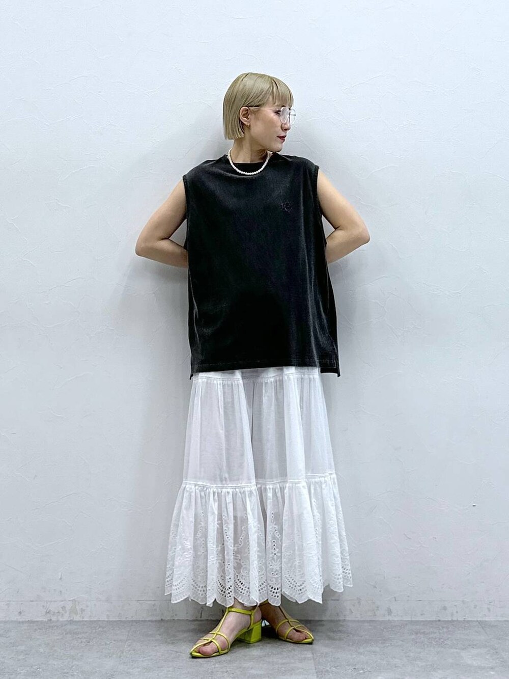 ブラック系のTシャツ/カットソー、ホワイト系のスカート、ブラック系のメガネを着用したレディースの夏コーディネートの3枚目の写真
