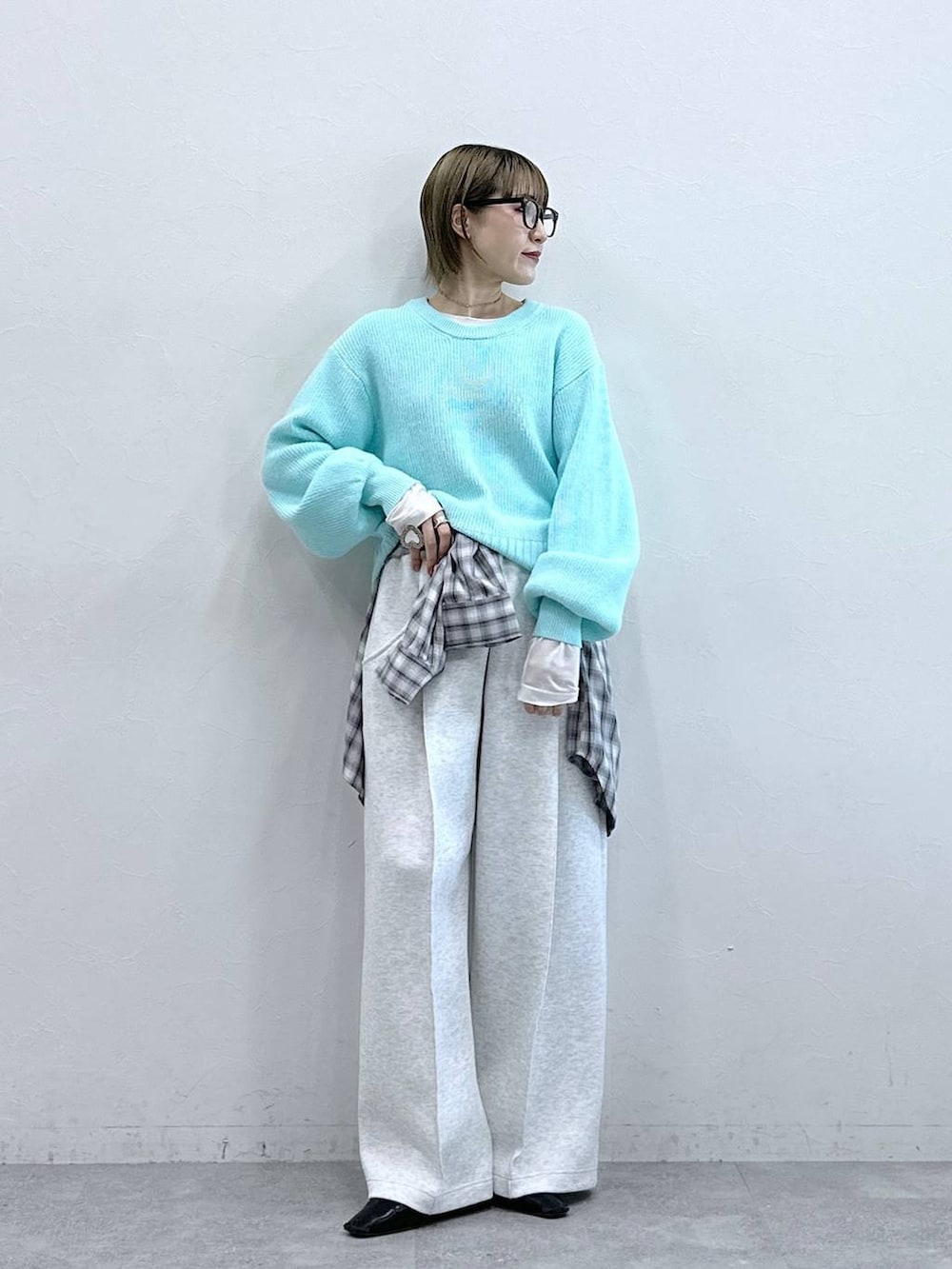 ホワイト系のスウェットパンツ、ブルー系のニット/セーター、ホワイト系のTシャツ/カットソーを着用したレディースの冬コーディネートの2枚目の写真