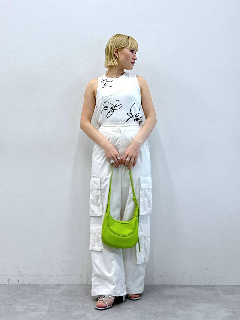 シルバー系のサンダル、ホワイト系のタンクトップ、ホワイト系のカーゴパンツを着用したレディースの夏コーディネートの3枚目の写真