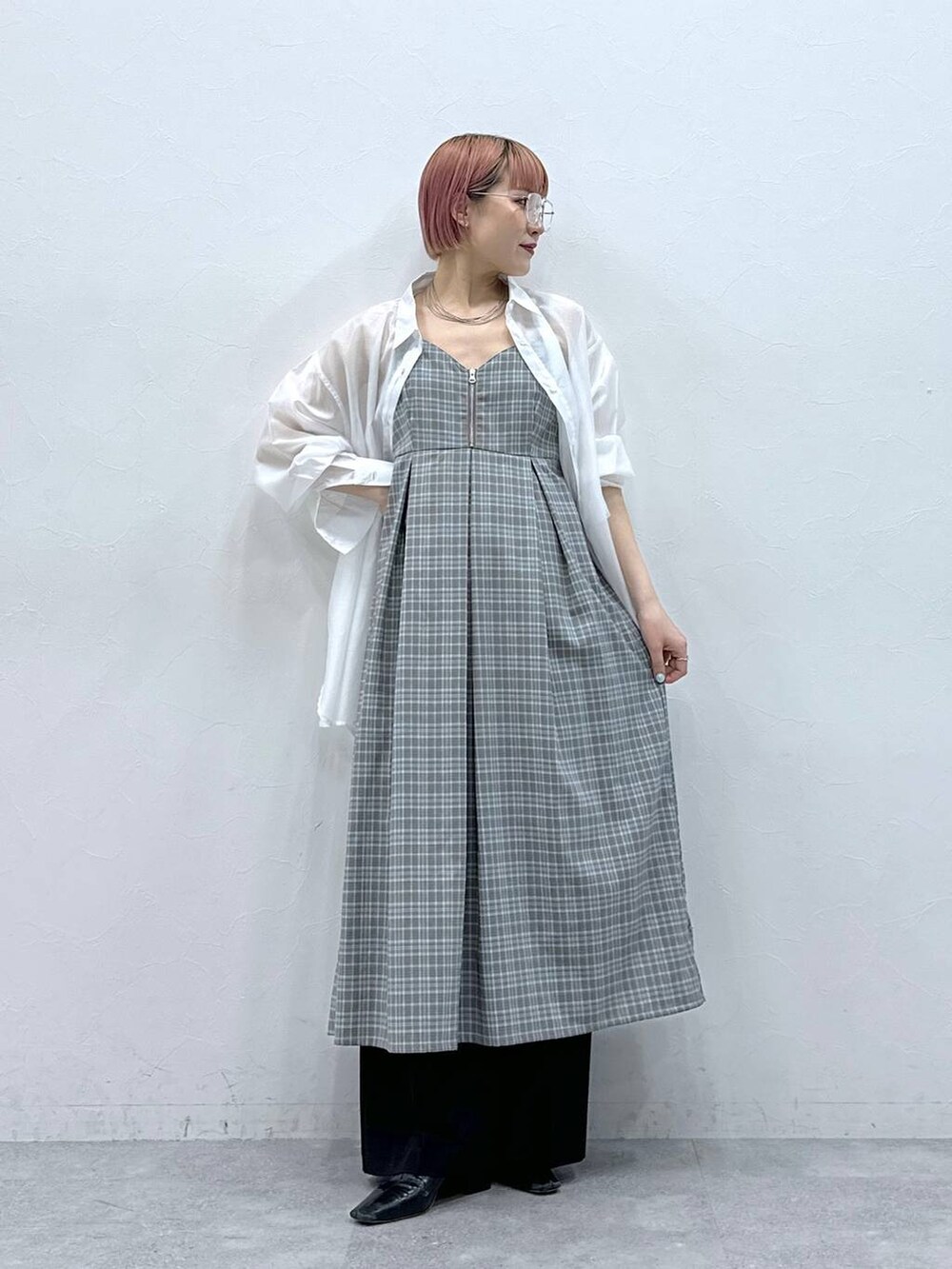 ホワイト系のシャツ/ブラウス、グレー系のワンピース、ブラック系のスラックスを着用したレディースの春コーディネートの2枚目の写真