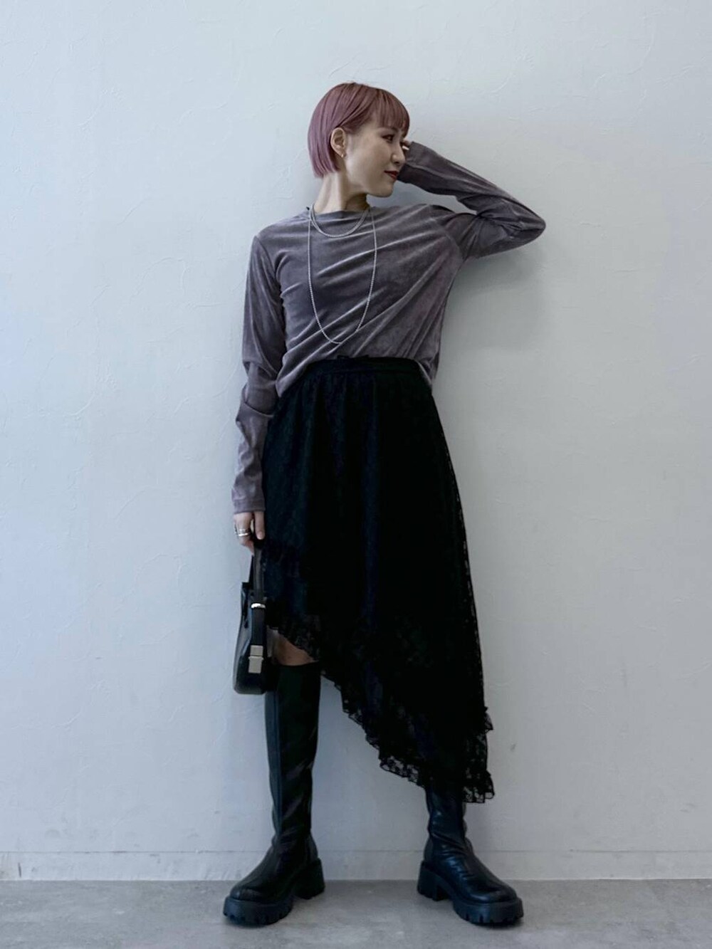 ブラック系のブーツ、パープル系のTシャツ/カットソー、ブラック系のスカートを着用したレディースの冬コーディネートの2枚目の写真