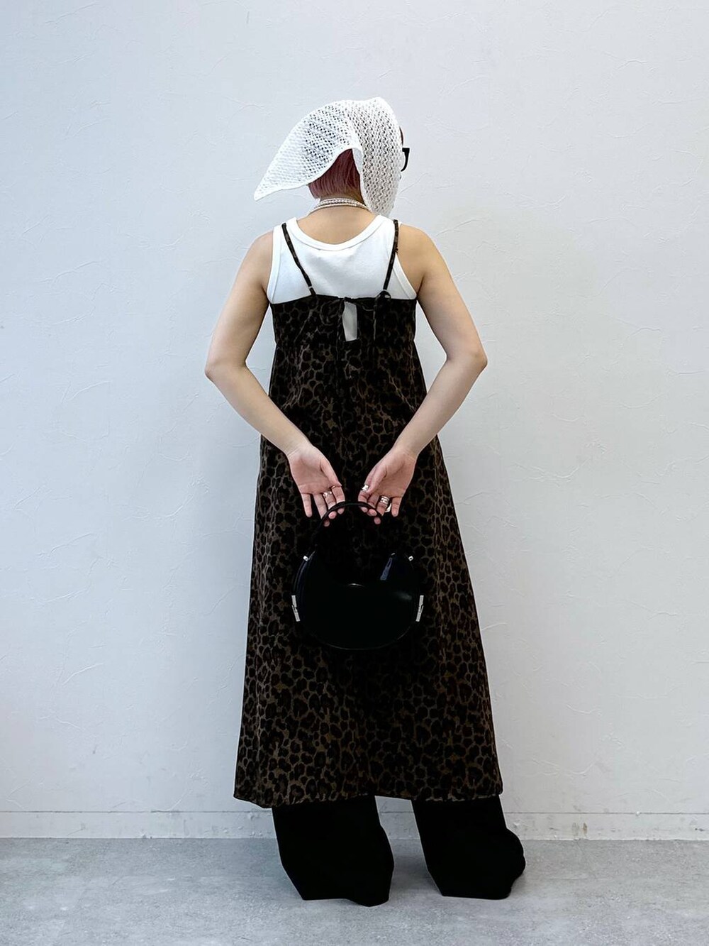 ブラウン系のワンピース、ホワイト系のタンクトップ、ブラック系のスラックスを着用したレディースの春コーディネートの5枚目の写真