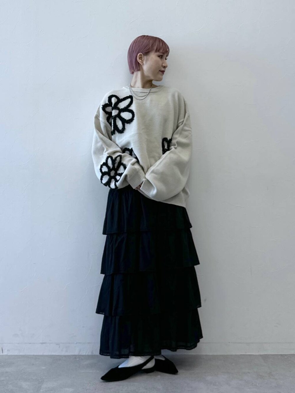 ブラック系のスカート、ホワイト系のニット/セーターを着用したレディースの冬コーディネートの3枚目の写真