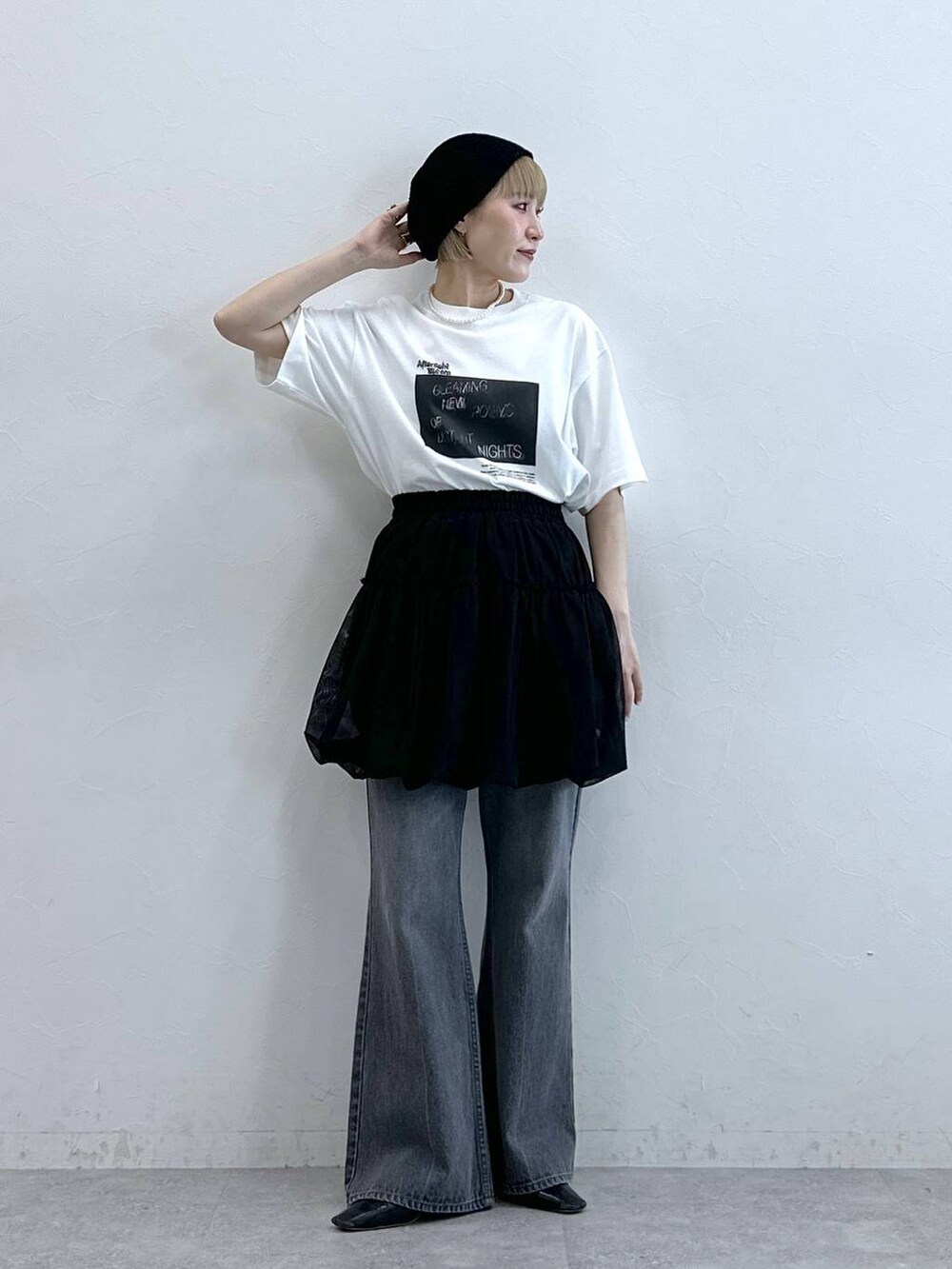 グレー系のデニムパンツ、ブラック系のスカート、ブラック系のニットキャップ/ビーニーを着用したレディースの夏コーディネートの4枚目の写真
