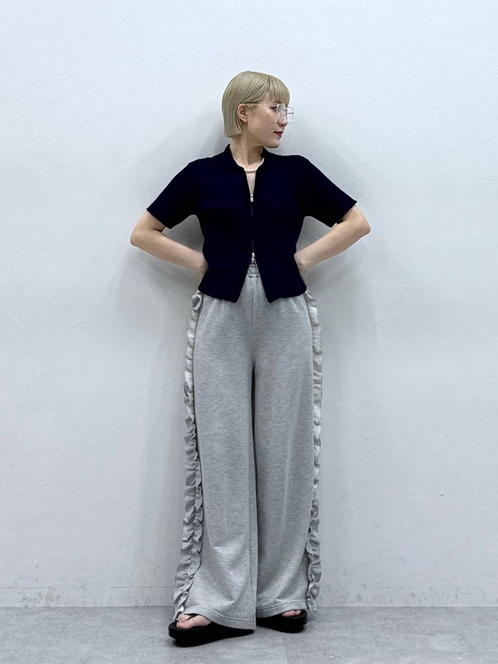 グレー系のスウェットパンツ、ブルー系のニット/セーター、ブラック系のサンダルを着用したレディースの夏コーディネートの2枚目の写真