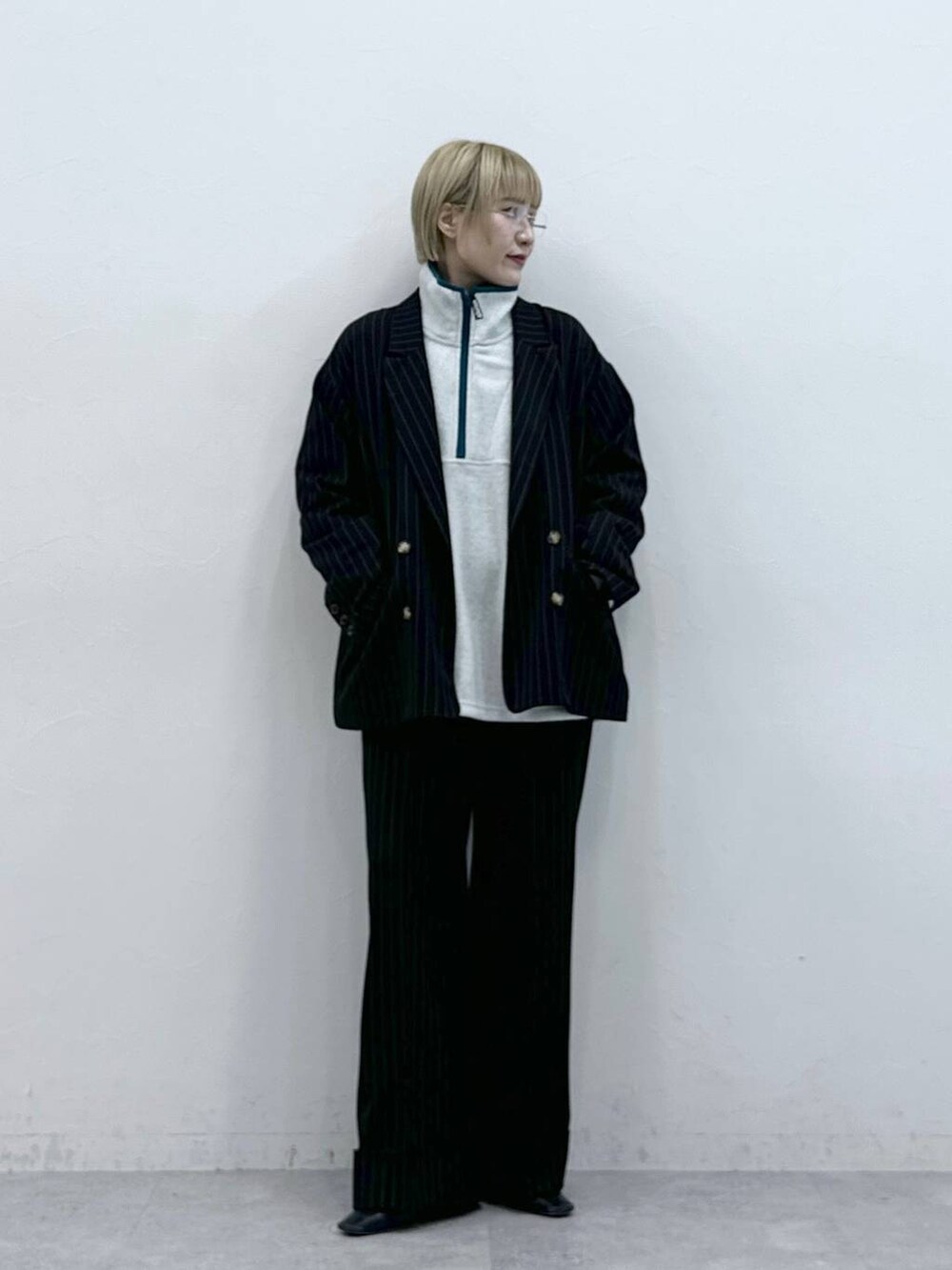 ホワイト系のスウェット、ブラック系のスラックス、ブラック系のテーラードジャケットを着用したレディースの秋コーディネートの2枚目の写真